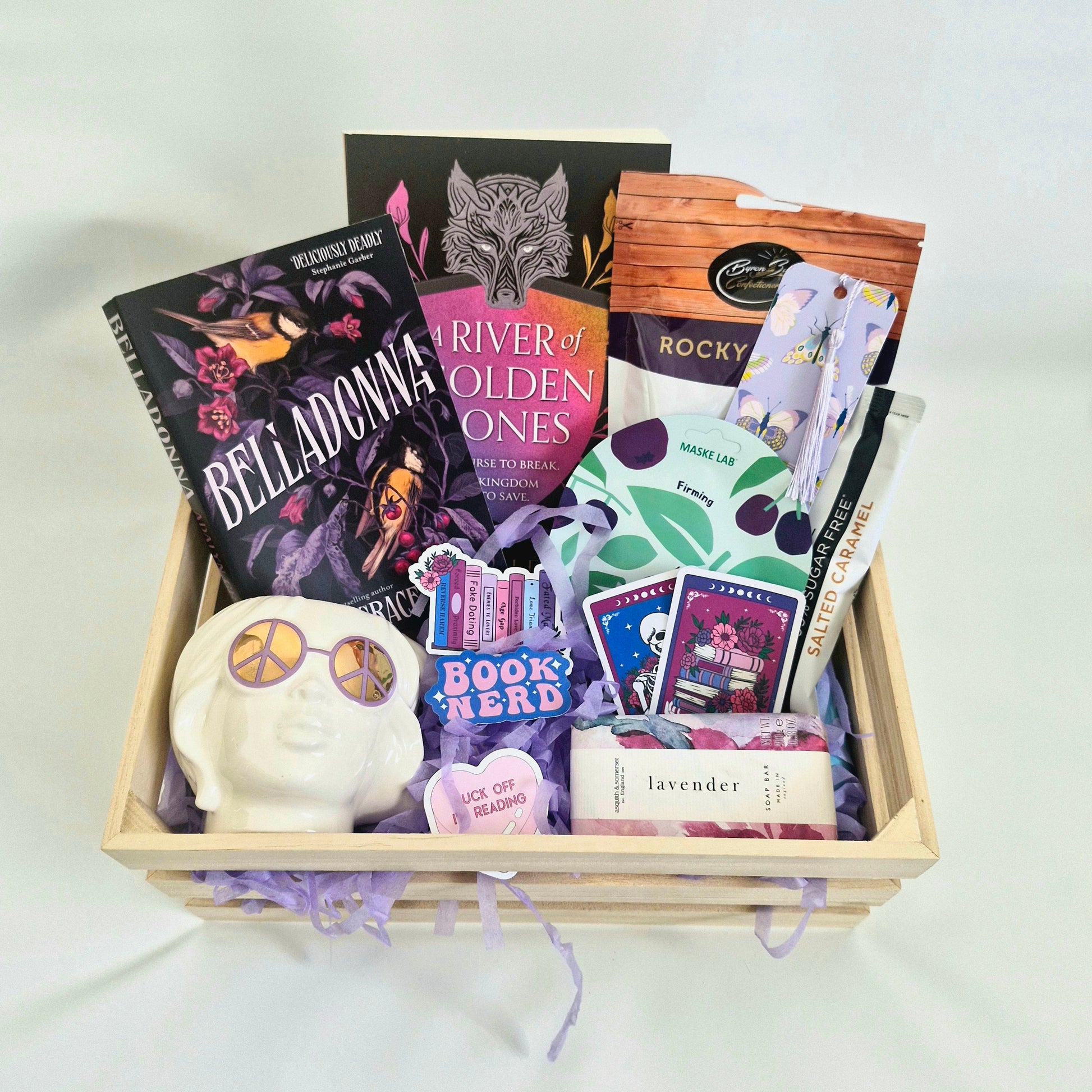 book subscription box for readers, gift box with belladonna by adalyn grace, and a river of golden bones, rocky road, face mask, coffee cup, stickers, soap, bookmark, coffee, fantasy paperbacks