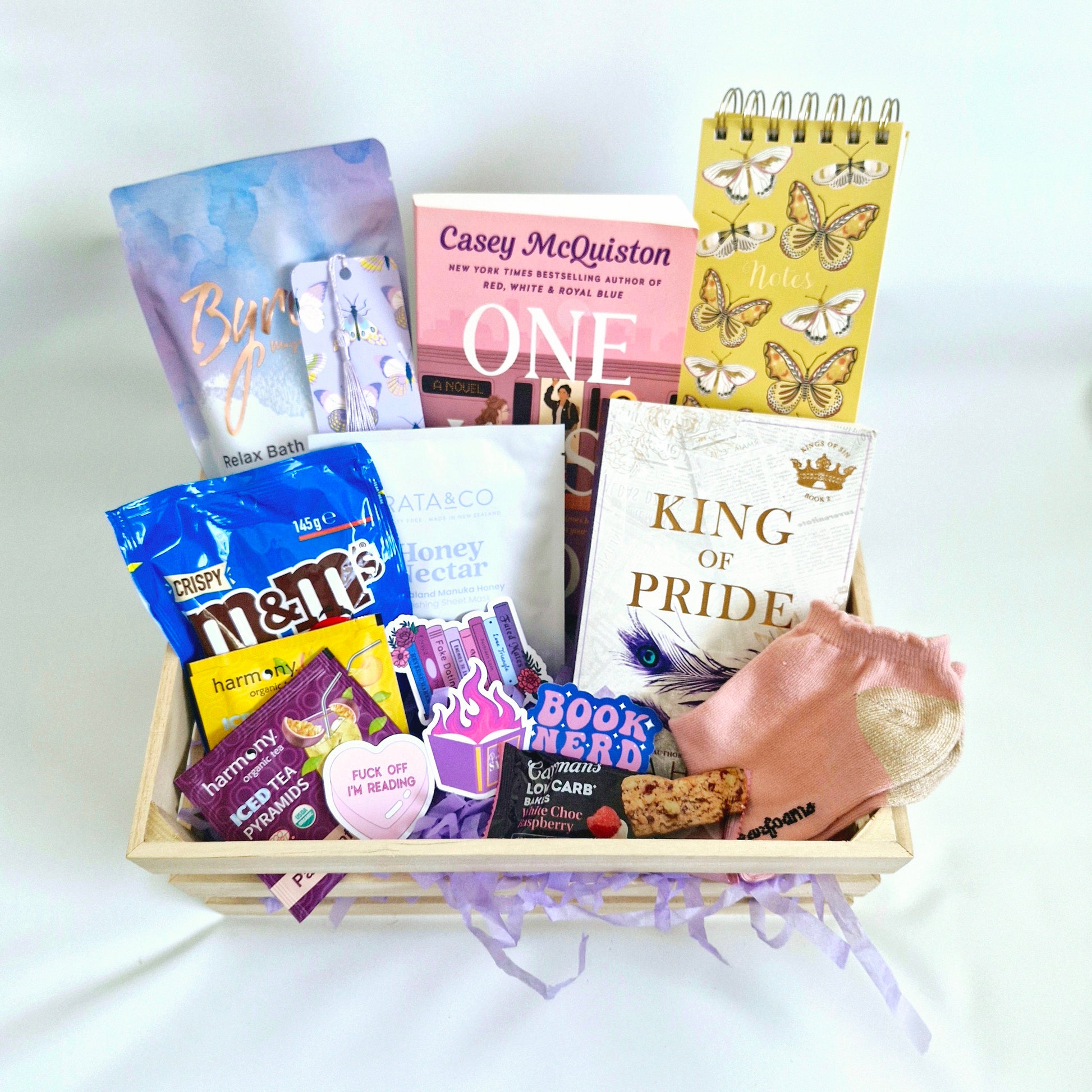 readers subscription book box, with King of Pride by Ana Huang, One Last stop by Casey Mcquiston, chocolate confectionary, face mask, socks, byron bay bath salts, notebook, romance book gift box