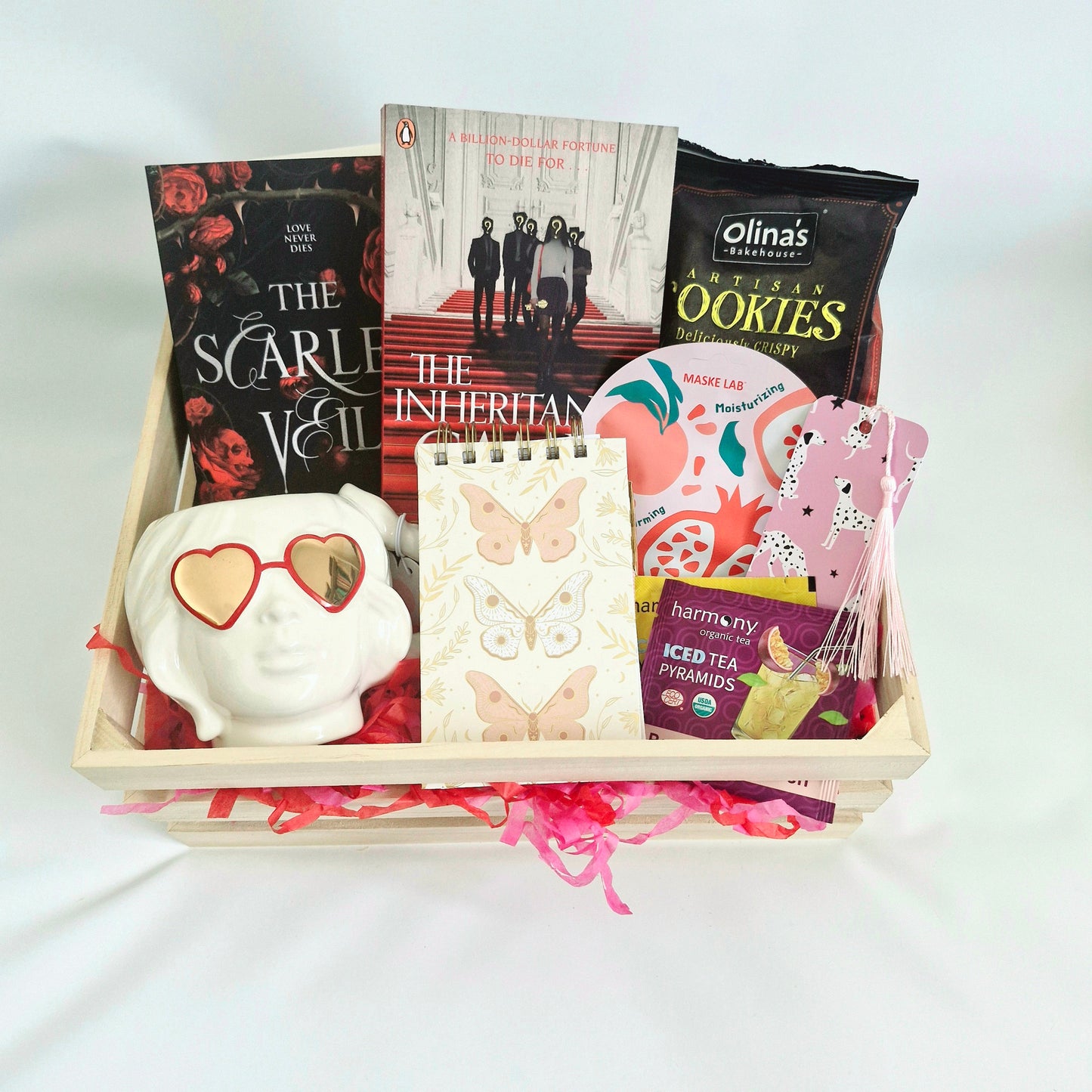 readers book subscription box with the inheritance games and the scarlet veil, cookies, coffee cup, face mask, notepad, tea, bookmark, paperback gift box