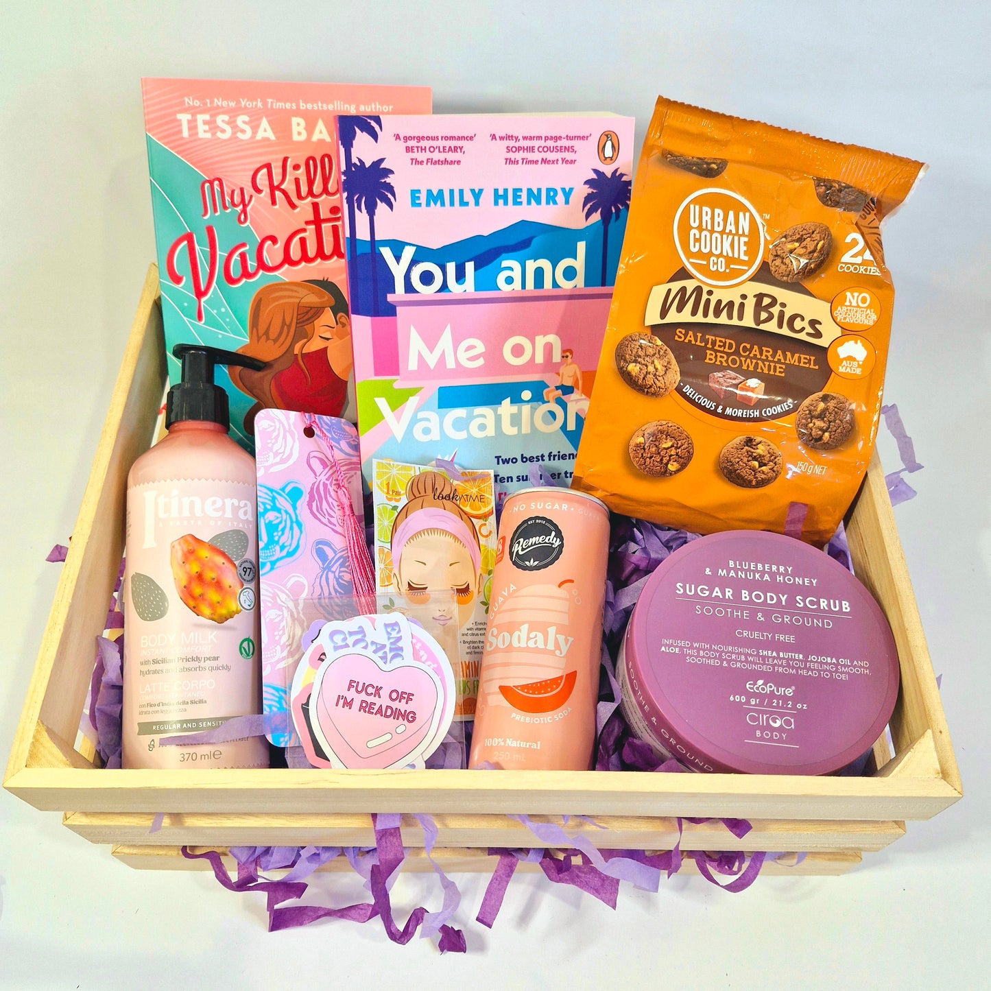 readers book subscription box with My Killer Vacation by Tessa Bailley, and You and Me on Vacation by Emily Henry, with cookies, body lotion moisturiser, soda can, snacks and drinks, sugar scrub, bookmarks and stickers, bookish merch, gift box