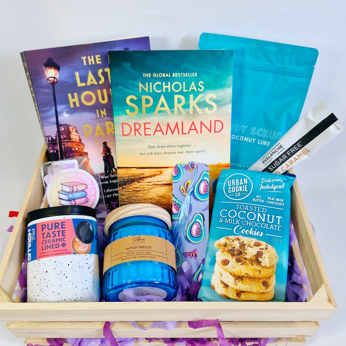 reading subscription box, with books Dreamland by Nicholas Sparks, with body scrub, candle, cookies and snacks, metal coffee cup, bookmarks and stickers and bookish merch, coffee, book box subscription delivery